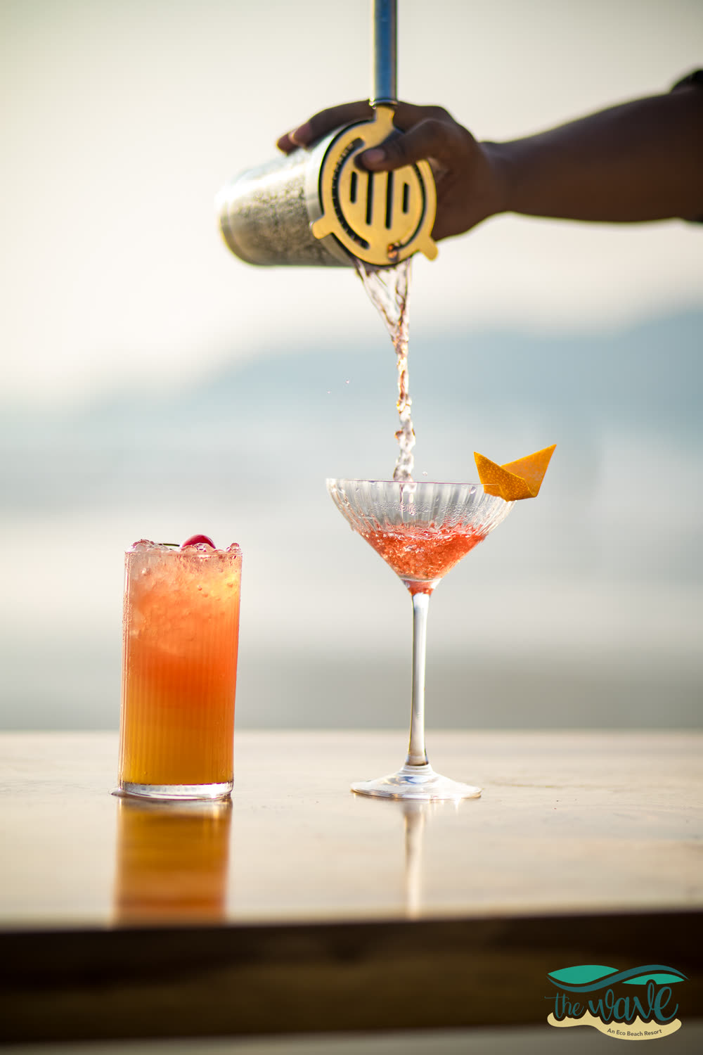 A cocktail being poured at the bar