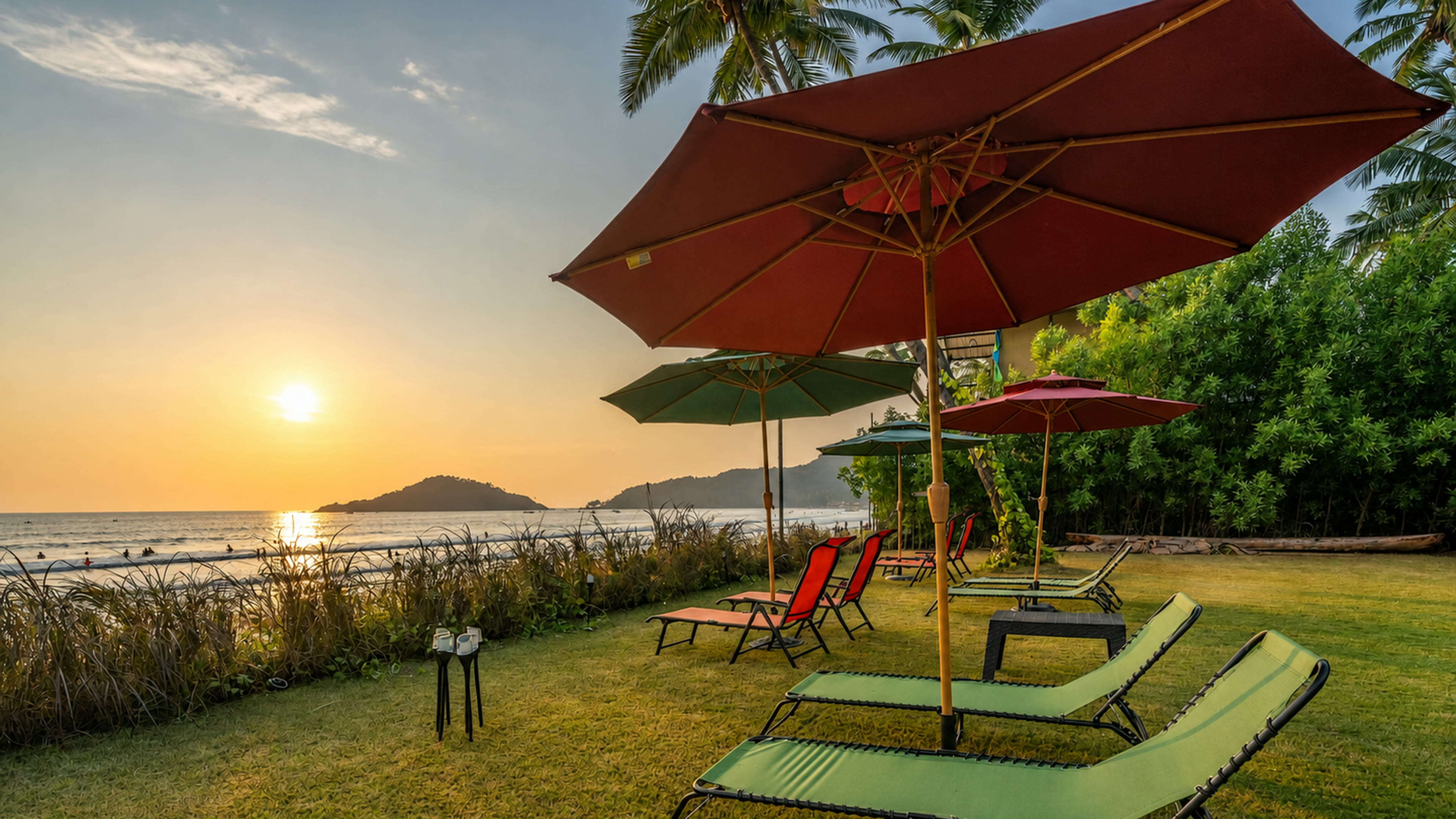 Sunset loungers beneath umbrellas on The Wave Goa beachfront lawn